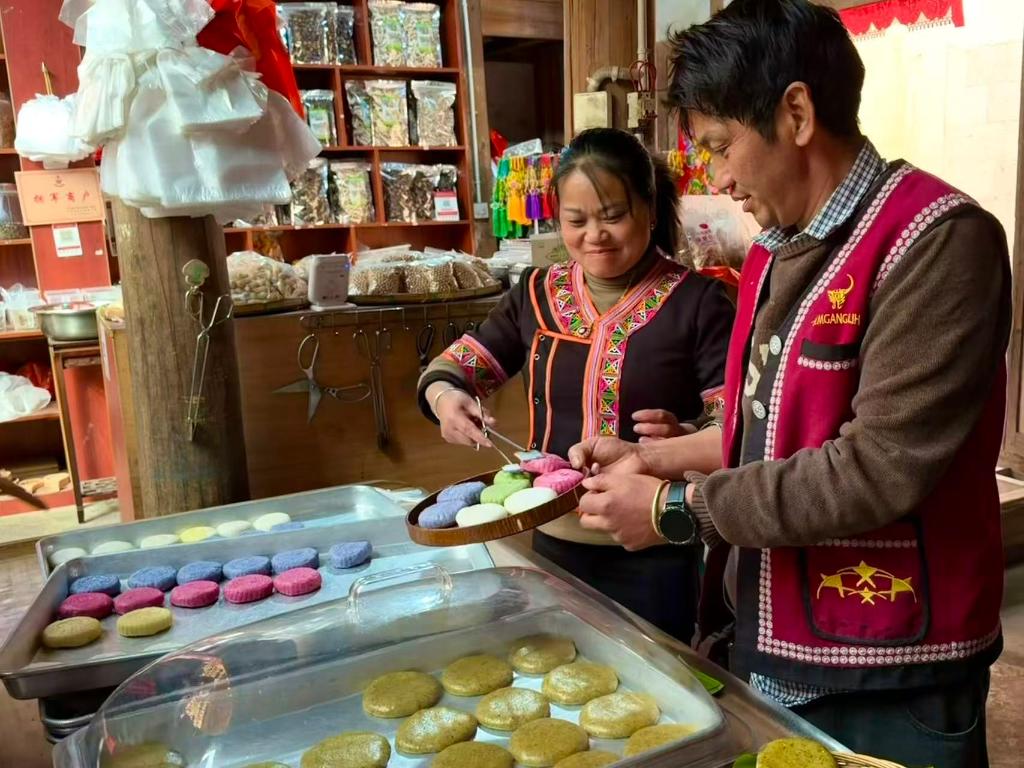 2026年1月27日,云南省腾冲市清水镇司莫拉佤族村村民李发顺夫妇正在为游客打包大米粑粑。